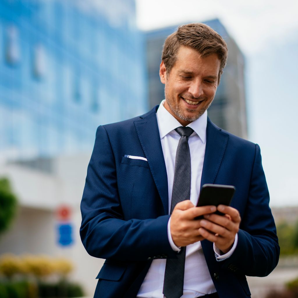 Homem sorrindo com celular na mão