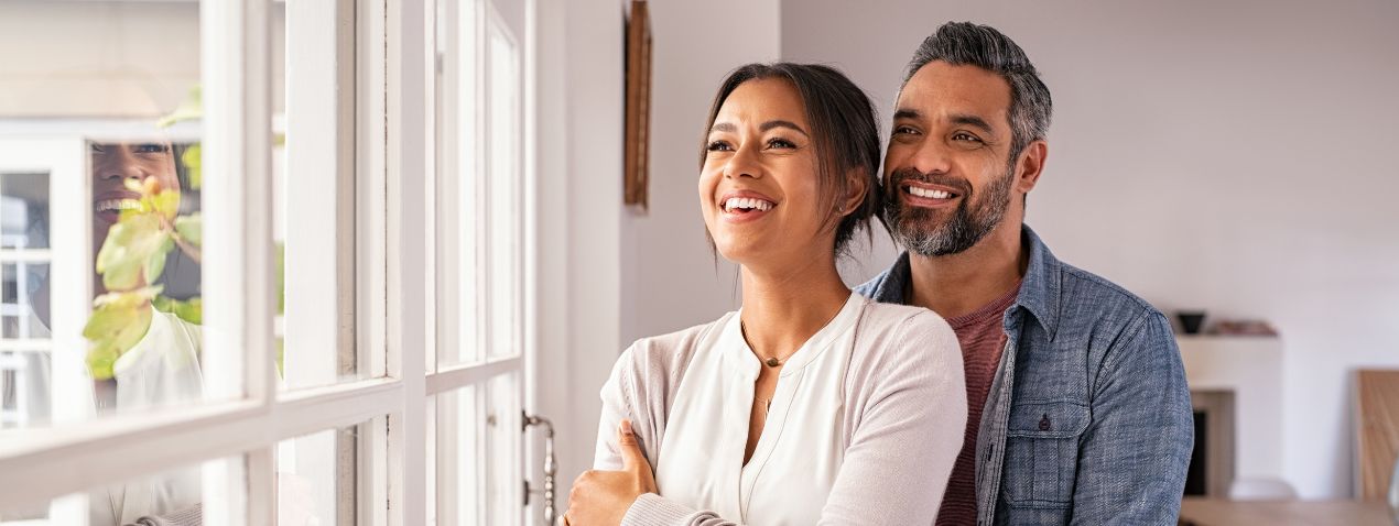 Casal feliz olhando pela janela